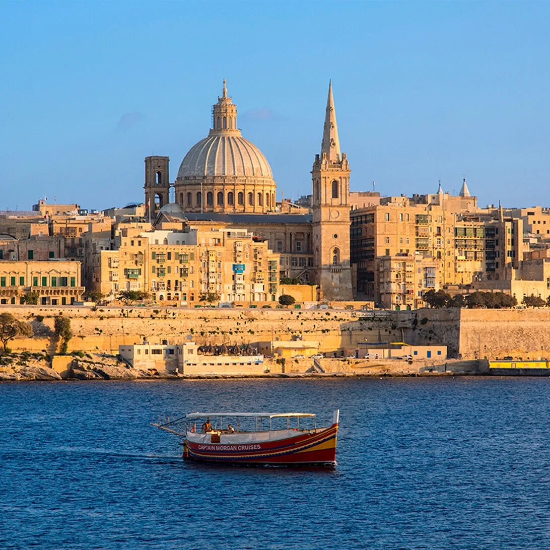 Pastel-colored Mediterranean town with bell tower by the sea
