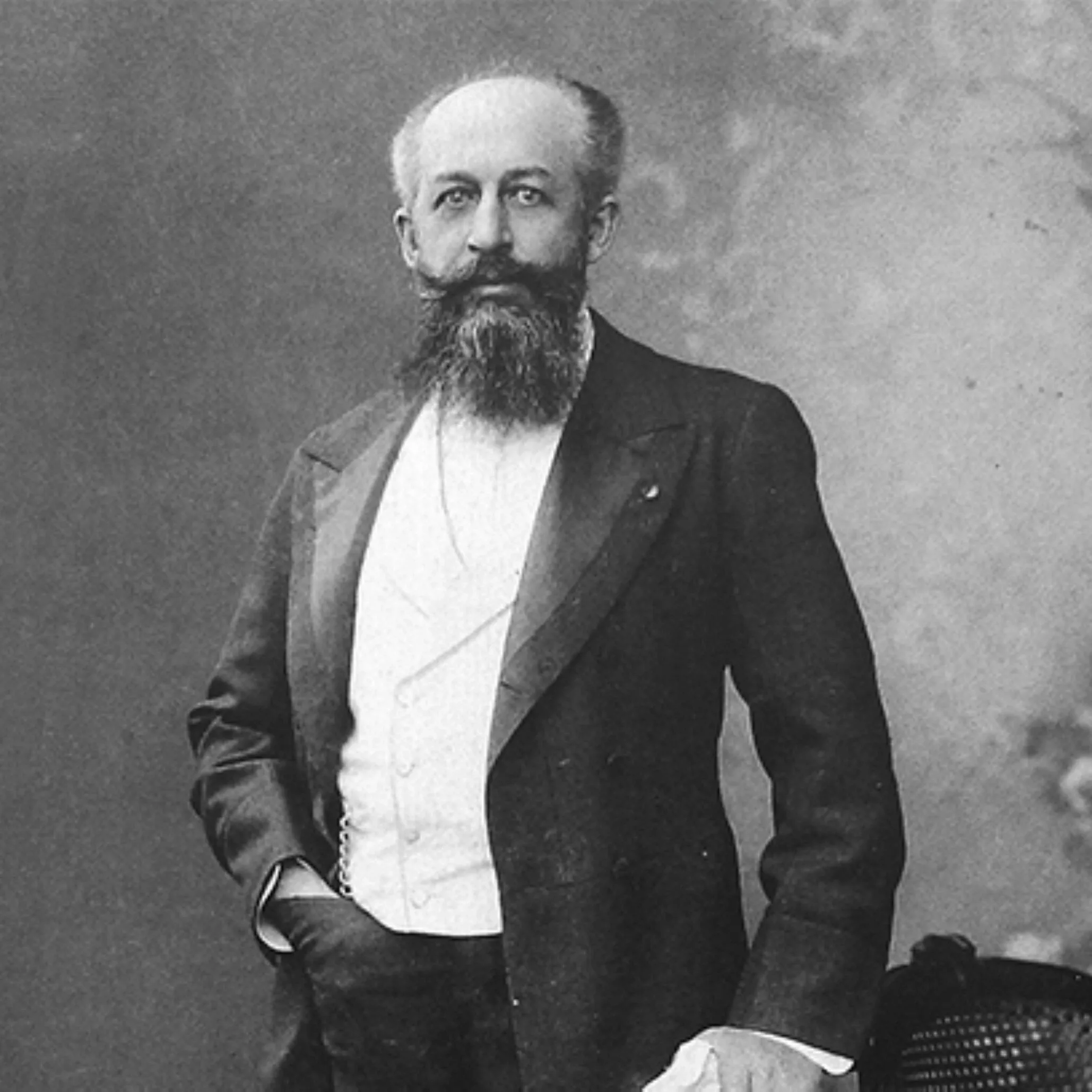 Nagelmackers portrait of a bearded man standing in a formal suit in a 19th-century studio with neutral backdrop