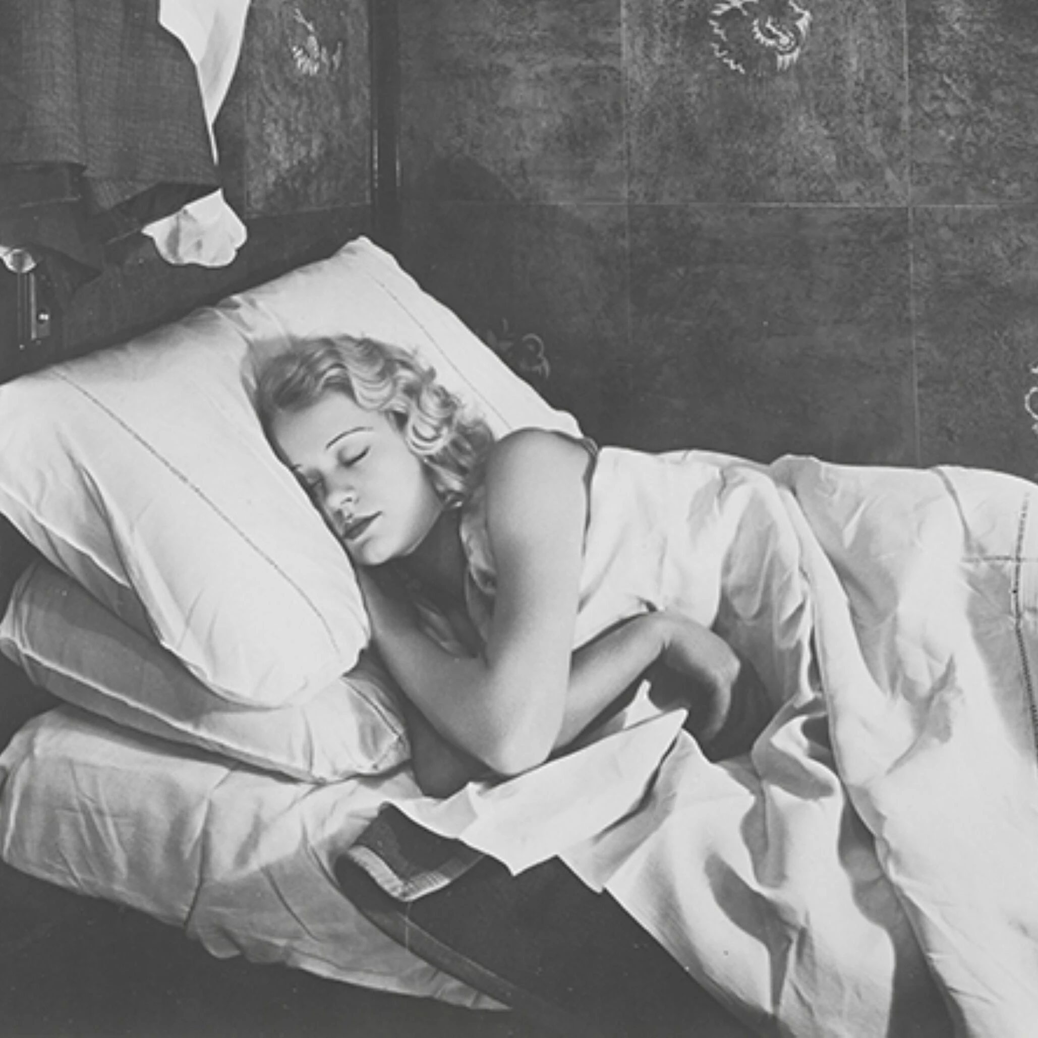 Orient Express passenger sleeping on a white-sheeted berth in a vintage sleeper cabin 